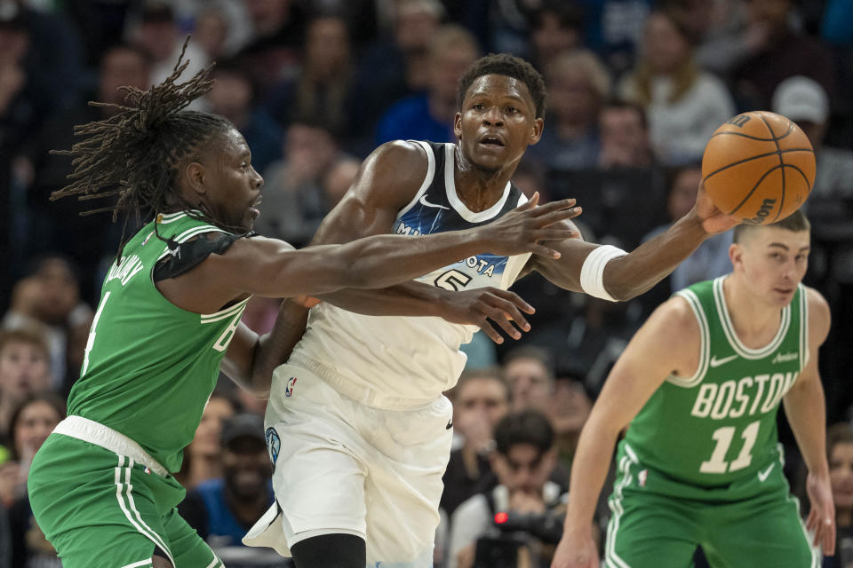 Jan 2, 2025; Minneapolis, Minnesota, USA; Minnesota Timberwolves guard Anthony Edwards (5) passes around Boston Celtics guard Jrue Holiday (4) in the first half at Target Center. Mandatory Credit: Jesse Johnson-Imagn Images