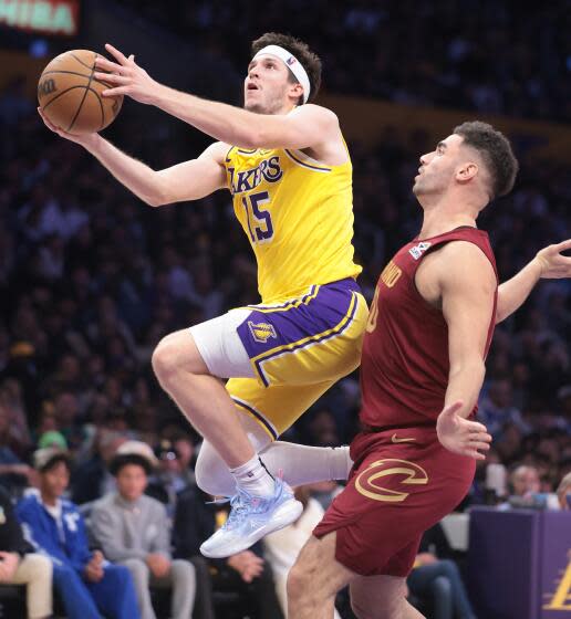 Laker Austin Reaves drives past Cavalier Georgres Niang at Crypto.com Arena on Tuesday.