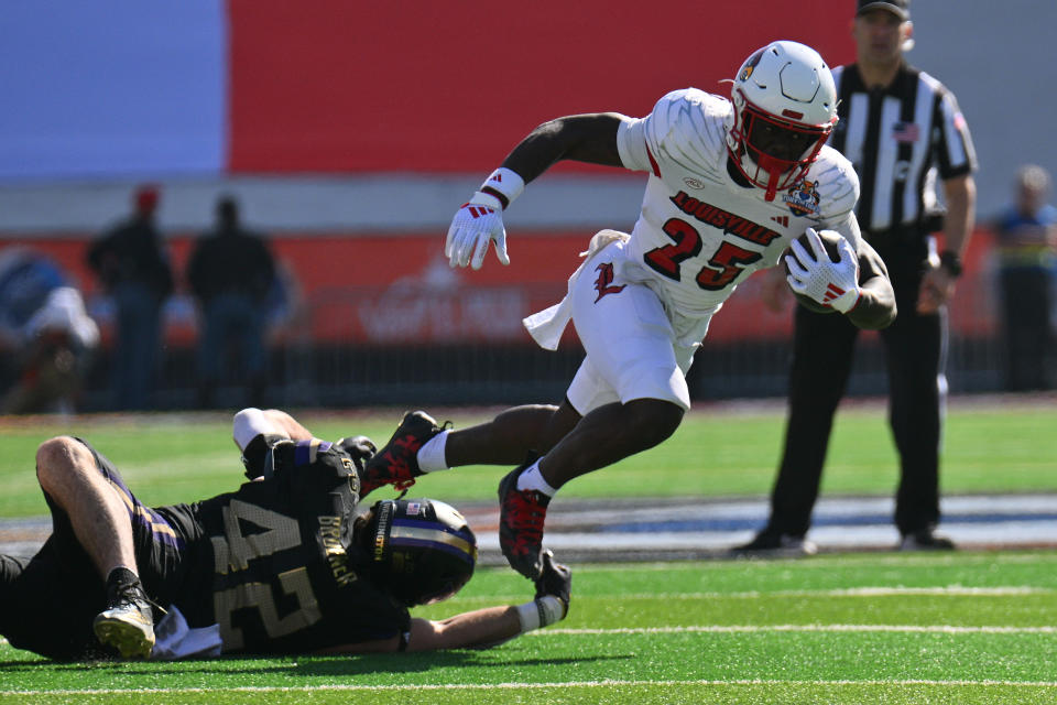 EL PASO, TEXAS - DECEMBER 31: Running back Isaac Brown #25 of the Louisville Cardinals escapes a tackle from linebacker Carson Bruener #42 of the Washington Huskies during the first half of the Tony the Tiger Sun Bowl at Sun Bowl Stadium on December 31, 2024 in El Paso, Texas. (Photo by Sam Wasson/Getty Images)