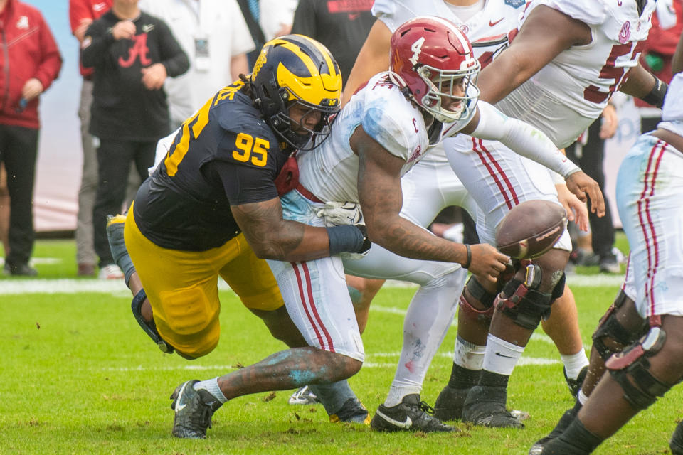 TAMPA, FLORIDA - DECEMBER 31: Trey Pierce #95 of the Michigan Wolverines tackles Jalen Milroe #4 of the Alabama Crimson Tide during the first half of the 2024 ReliaQuest Bowl at Raymond James Stadium on December 31, 2024 in Tampa, Florida. (Photo by Aaron J. Thornton/Getty Images)