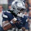 CeeDee Lamb carrying a football in a Dallas Cowboys uniform in an archival photo.
